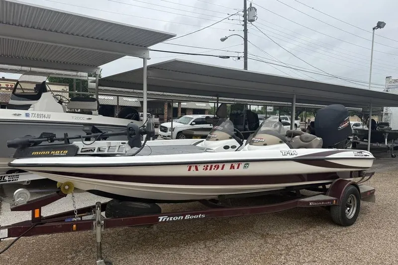 The Image of 2005 Triton TR-196 boat on trailer, parked under a metal canopy. - 1