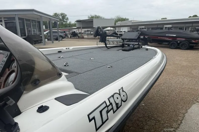 Slide: The Image of 2005 Triton TR-196 boat with spacious deck, parked outdoors. - 6