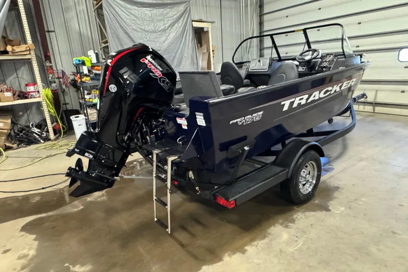 Slide: The Image of 2026 Tracker Pro Guide V-175 Combo boat in a garage, featuring a powerful outboard motor. - 3