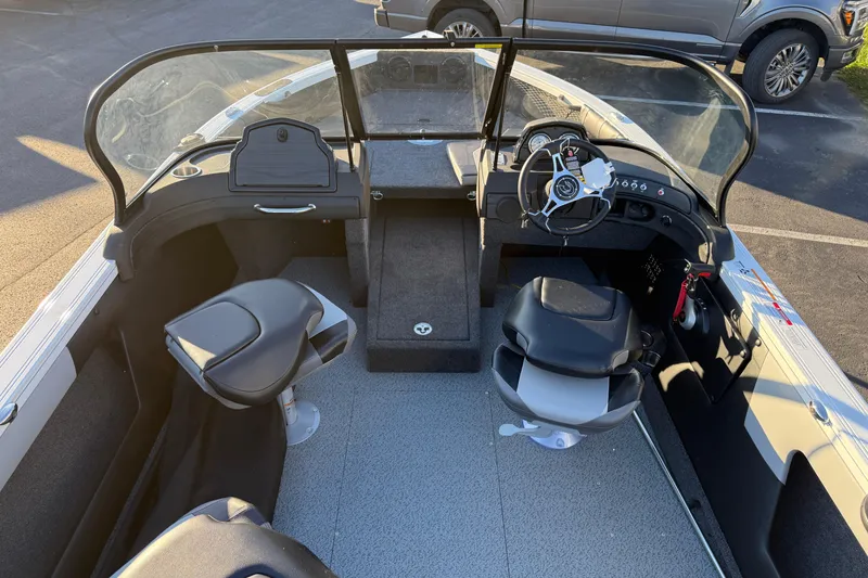 Slide: The Image of 2026 Crestliner 1850 Super Hawk interior with steering wheel and seating, parked outdoors. - 12
