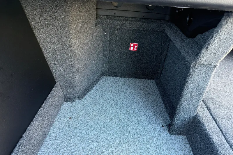 Slide: The Image of Carpeted interior of 2026 Crestliner 1850 Super Hawk boat, featuring a fire extinguisher symbol. - 16