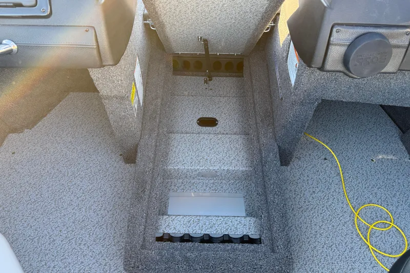 Slide: The Image of 2026 Crestliner 1850 Super Hawk interior with storage compartments and carpeted flooring. - 17