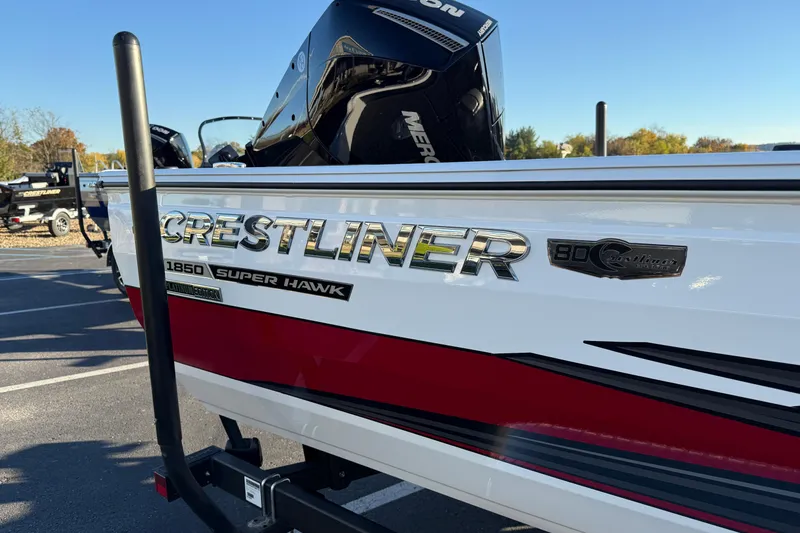 Slide: The Image of 2026 Crestliner 1850 Super Hawk boat with Mercury engine, parked outdoors. - 2
