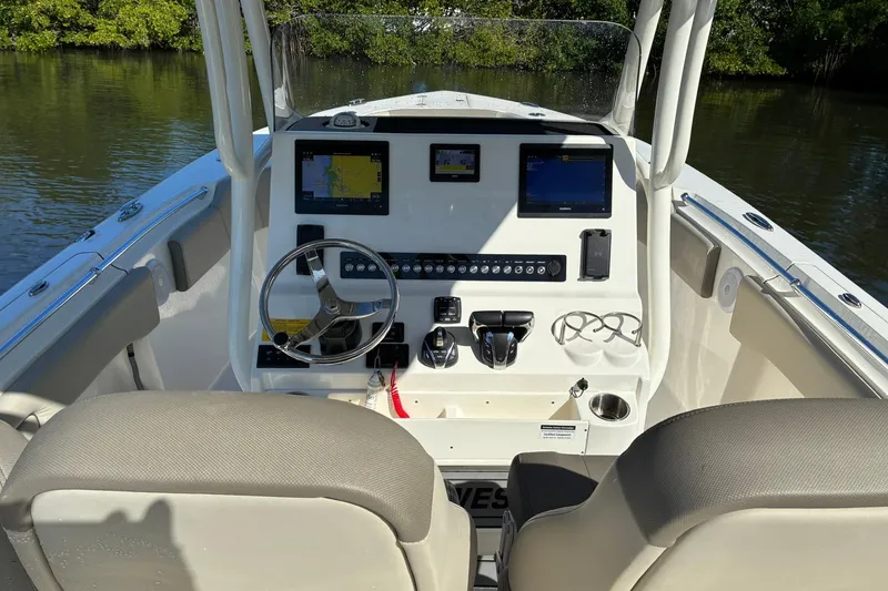 Slide: The Image of 2022 Key West 263 FS boat dashboard with navigation screens and steering wheel. - 11