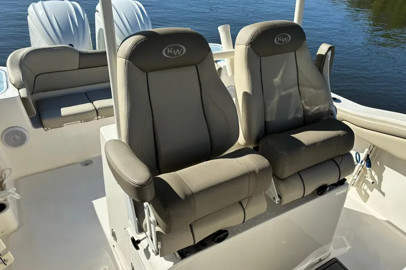 Slide: The Image of 2022 Key West 263 FS boat interior with dual cushioned seats and water backdrop. - 12