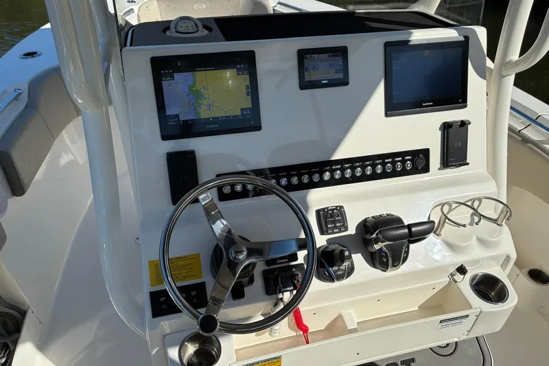 Slide: The Image of 2022 Key West 263 FS boat dashboard with navigation screens and steering wheel. - 13