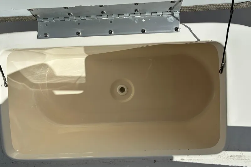 Slide: The Image of 2022 Key West 263 FS boat compartment with open lid and visible hinge. - 18