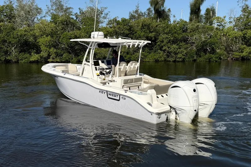 Slide: The Image of 2022 Key West 263 FS boat with dual engines cruising on a calm river. - 6