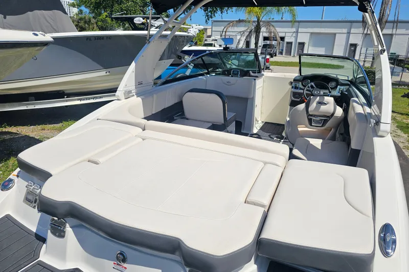 Slide: The Image of 2017 Chaparral 227 SSX boat interior with seating and steering wheel, parked outdoors. - 15
