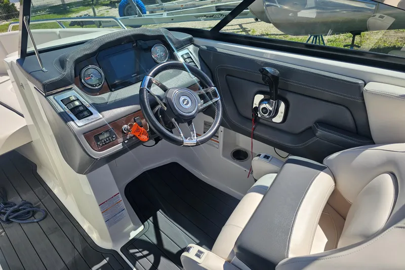 Slide: The Image of 2017 Chaparral 227 SSX boat cockpit with steering wheel and dashboard controls. - 19