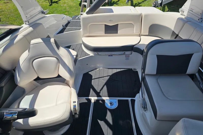 Slide: The Image of 2017 Chaparral 227 SSX boat interior with white and black seating, sunny day. - 21
