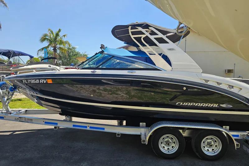 Slide: The Image of 2017 Chaparral 227 SSX boat on trailer, parked outdoors with palm trees in background. - 7