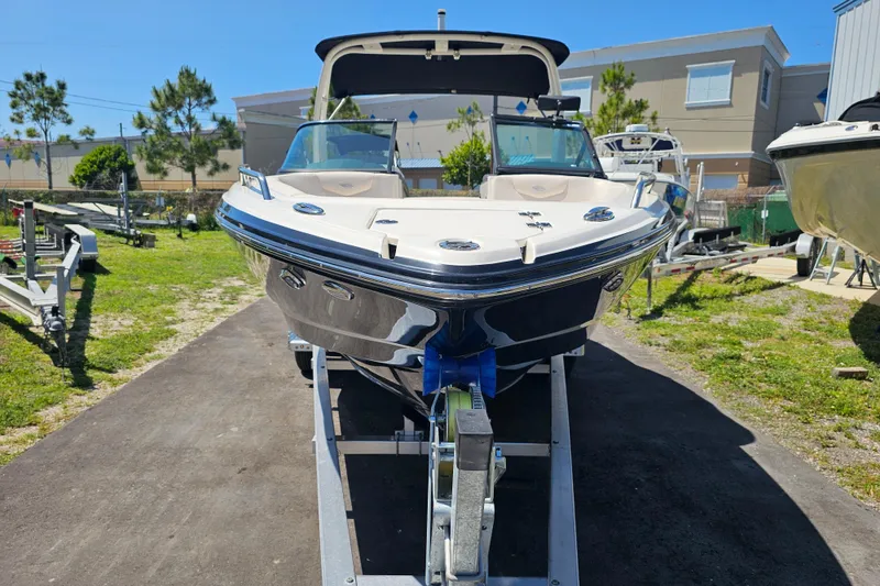 Slide: The Image of 2017 Chaparral 227 SSX boat on trailer, parked outdoors under clear blue sky. - 9