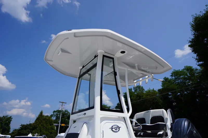 Slide: The Image of 2026 Tidewater 198 CC Adventure boat with T-top under clear blue sky. - 17