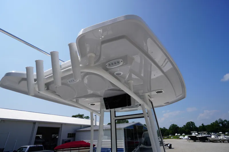 Slide: The Image of 2026 Tidewater 198 CC Adventure boat T-top with rod holders under clear blue sky. - 42