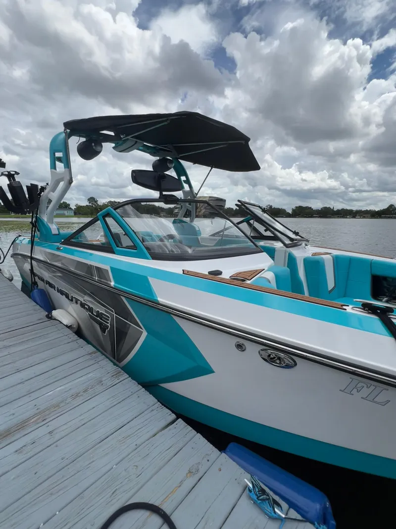 Slide: The Image of 2018 Nautique Super Air G23 boat docked under cloudy skies. - 1