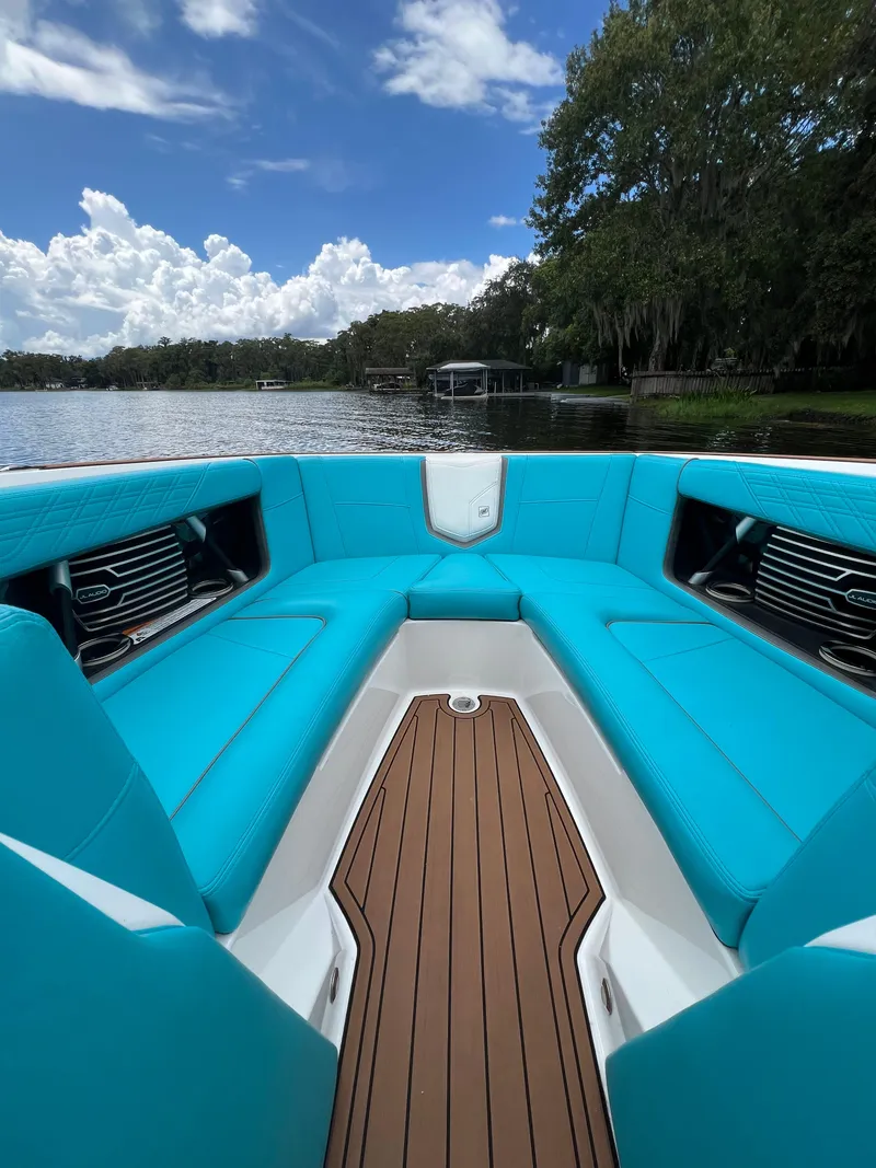 Slide: The Image of 2018 Nautique Super Air G23 boat with turquoise seating on a scenic lake. - 3
