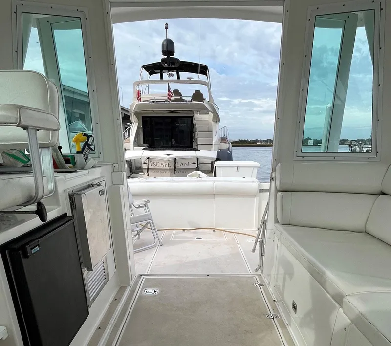 Slide: The Image of Interior view of 2005 Albin 31 Tournament Express boat with docked yacht in background. - 16