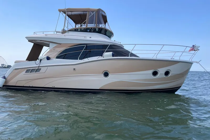 The Image of 2013 Carver C34 yacht on water, featuring sleek design and American flag. - 2