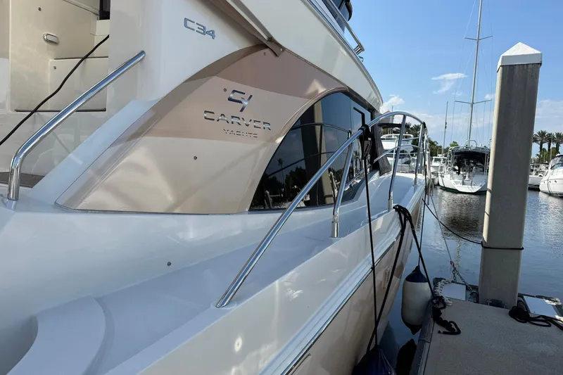 Slide: The Image of 2013 Carver C34 yacht docked at marina, featuring sleek design and polished railings. - 21
