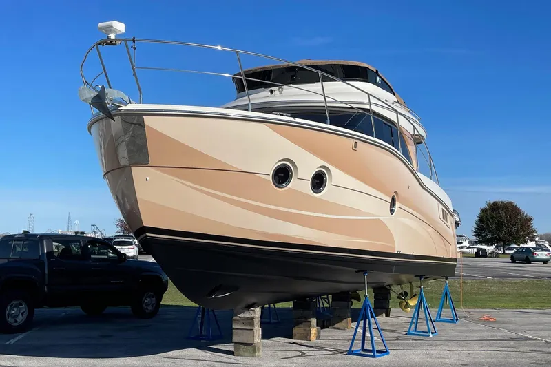Slide: The Image of 2013 Carver C34 yacht on stands, displayed outdoors under clear blue sky. - 43