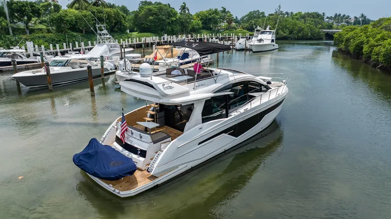 Slide: The Image of 2017 Galeon 510 Sky yacht docked in a serene marina with lush greenery. - 4