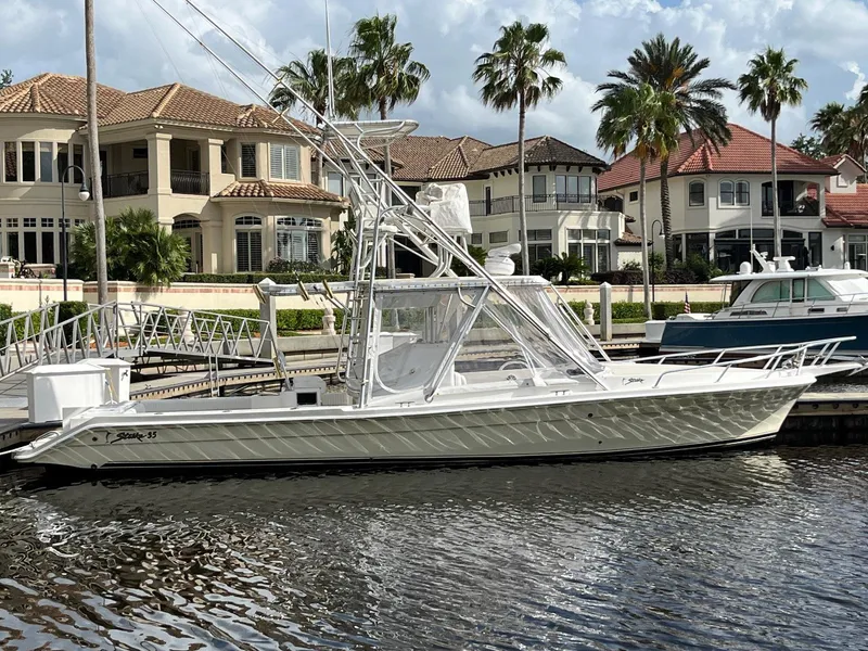 The Image of 2005 Strike 35 Sportfisherman boat docked near luxury waterfront homes. - 1