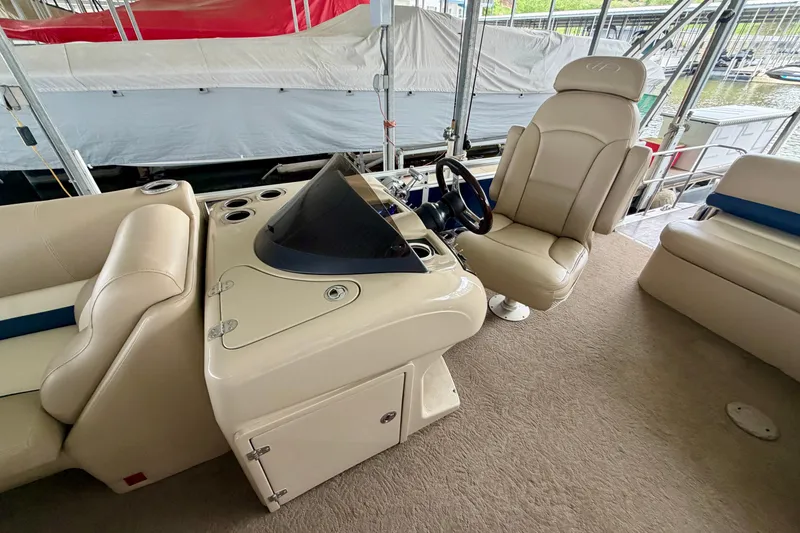 Slide: The Image of 2013 Harris Solstice 240 boat interior with helm, beige seating, and steering wheel. - 12
