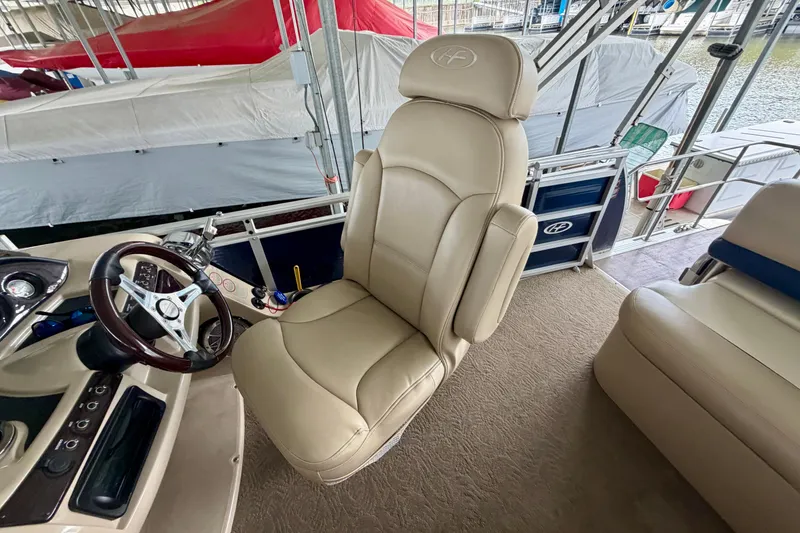 Slide: The Image of Captain's chair and helm of 2013 Harris Solstice 240 boat, featuring beige upholstery. - 20