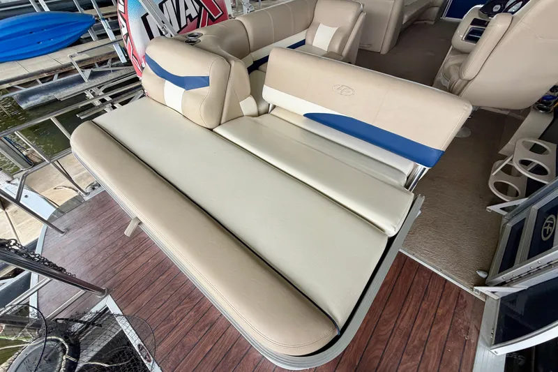 Slide: The Image of 2013 Harris Solstice 240 boat interior with beige and blue seating on wooden deck. - 22