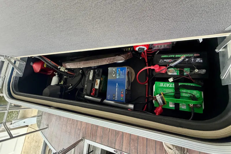 Slide: The Image of Storage compartment of a 2013 Harris Solstice 240 boat with batteries and equipment. - 24