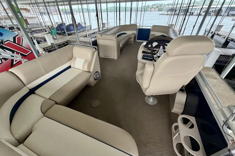 Slide: The Image of Interior of a 2013 Harris Solstice 240 pontoon boat with beige seating and steering console. - 28