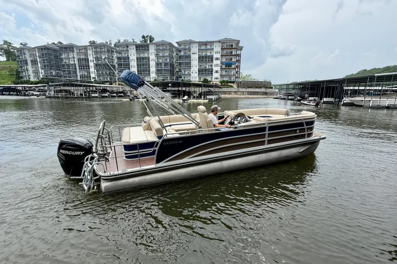 Slide: The Image of 2013 Harris Solstice 240 pontoon boat on a lake near modern apartments. - 3