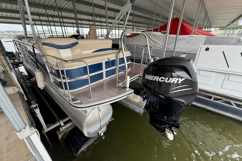 Slide: The Image of 2013 Harris Solstice 240 pontoon boat with Mercury outboard motor in covered dock. - 31