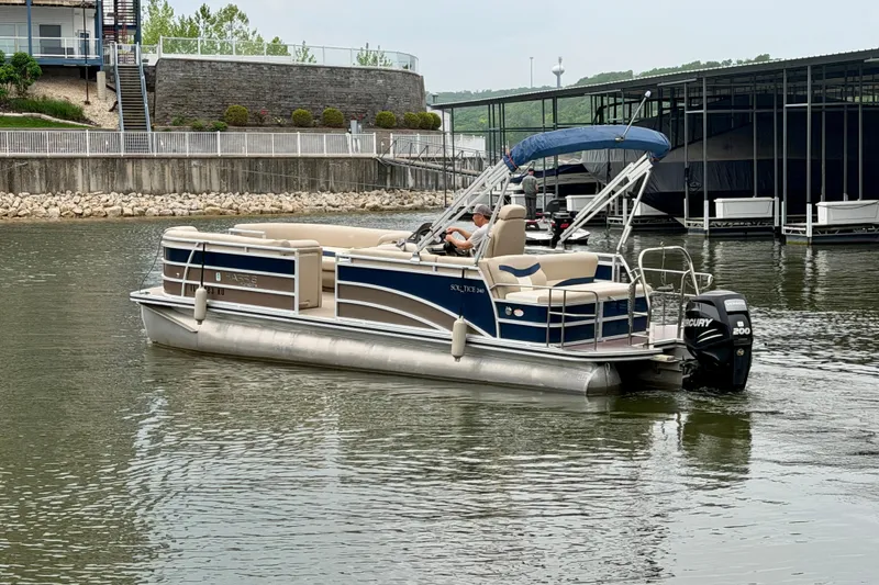 Slide: The Image of 2013 Harris Solstice 240 pontoon boat on a calm lake near a marina. - 6