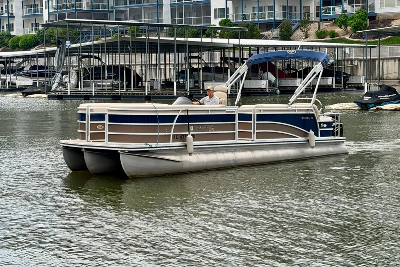Slide: The Image of 2013 Harris Solstice 240 pontoon boat cruising on a calm lake near a marina. - 7