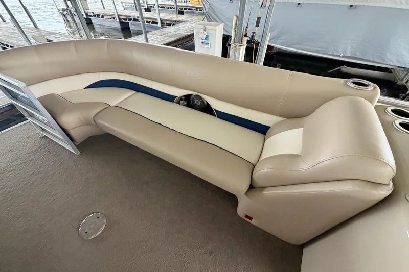 Slide: The Image of 2013 Harris Solstice 240 boat interior with beige seating and cup holders. - 9
