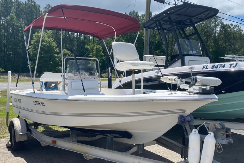 The Image of 2003 Seapro 1700 CC boat with red canopy on trailer, parked outdoors. - 1