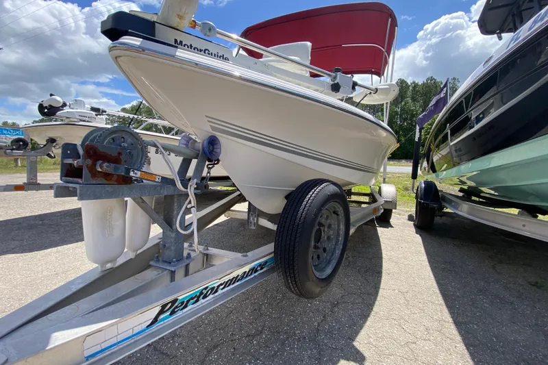 Slide: The Image of 2003 Seapro 1700 CC boat on trailer under blue sky, featuring a red canopy. - 10