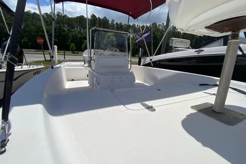 Slide: The Image of 2003 Seapro 1700 CC boat with white deck and red canopy, parked outdoors. - 12