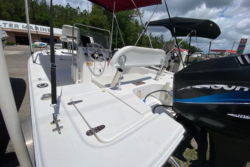 Slide: The Image of 2003 Seapro 1700 CC boat with console and outboard motor, parked outdoors. - 4