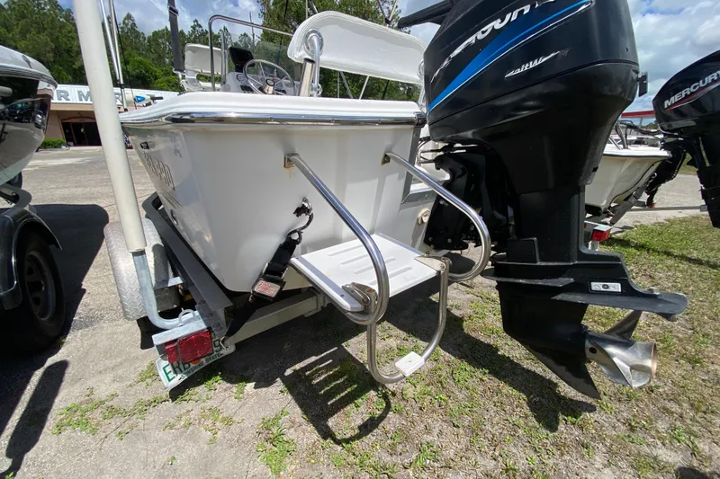 Slide: The Image of 2003 Seapro 1700 CC boat with outboard motor and swim ladder, parked on a trailer. - 5