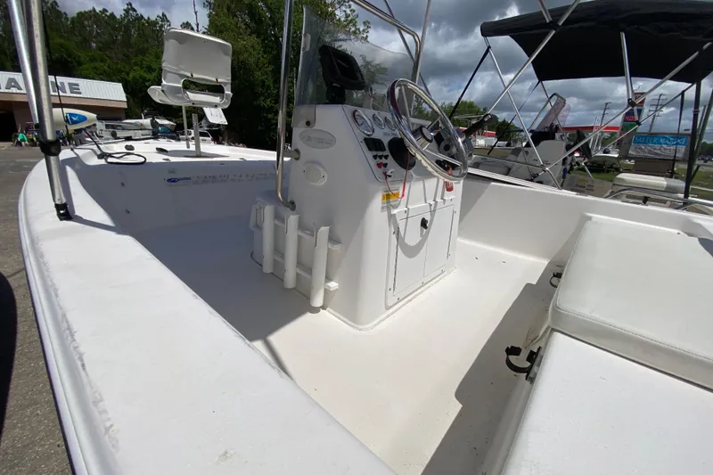 Slide: The Image of 2003 Seapro 1700 CC boat interior with steering console and seating, under cloudy sky. - 6