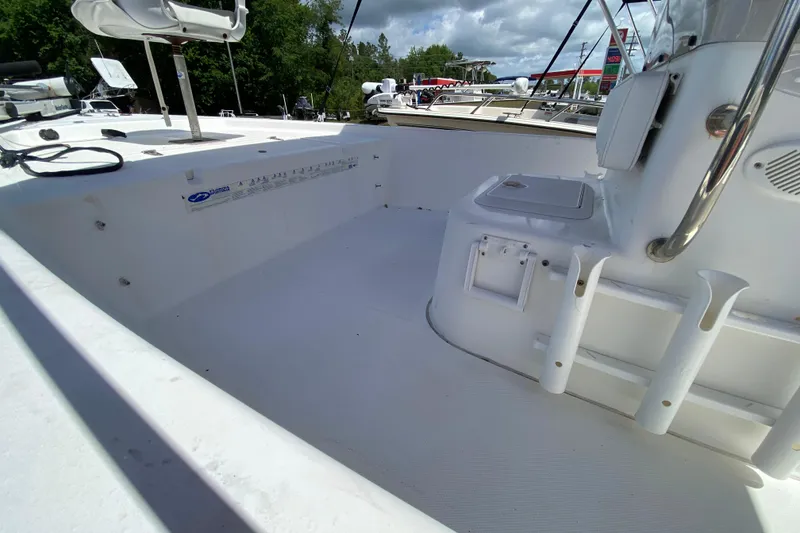 Slide: The Image of 2003 Seapro 1700 CC boat interior with seating and rod holders, under a partly cloudy sky. - 8