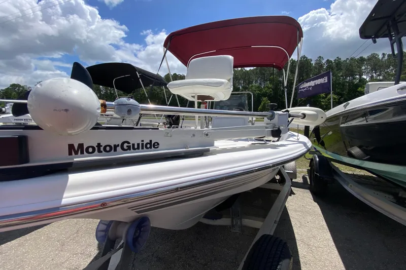 Slide: The Image of 2003 Seapro 1700 CC boat with MotorGuide trolling motor, parked under a sunny sky. - 9