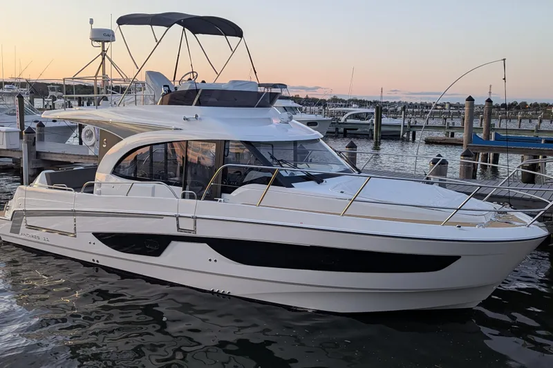 The Image of 2024 Beneteau Antares 11 Fly yacht docked at sunset in a marina. - 1