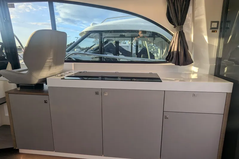 Slide: The Image of Interior view of 2024 Beneteau Antares 11 Fly, featuring modern cabinetry and seating. - 10