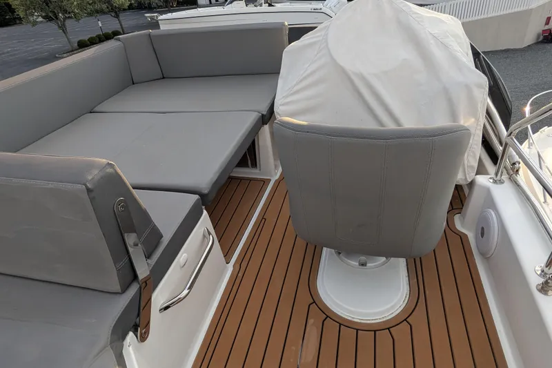 Slide: The Image of 2024 Beneteau Antares 11 Fly deck with cushioned seating and covered helm chair. - 23