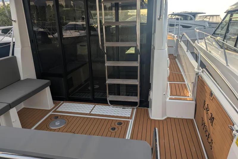 Slide: The Image of 2024 Beneteau Antares 11 Fly boat deck with seating and ladder. - 6