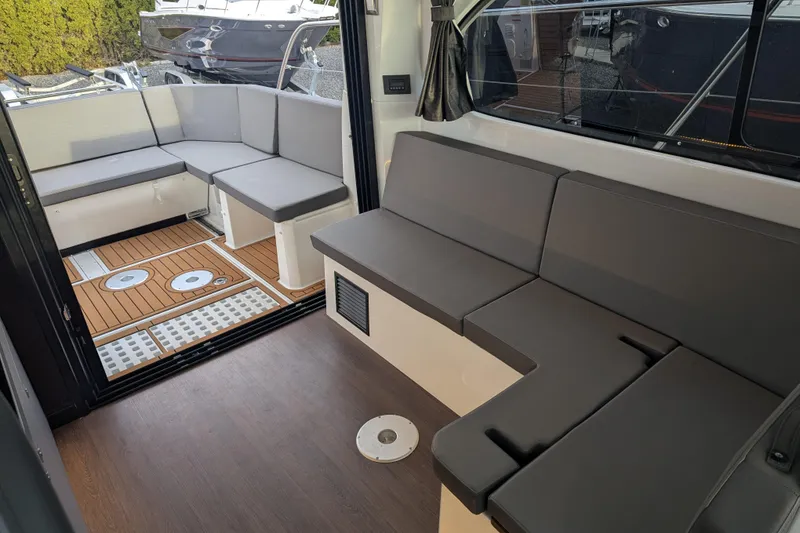 Slide: The Image of Interior seating area of 2024 Beneteau Antares 11 Fly with modern gray cushions. - 9